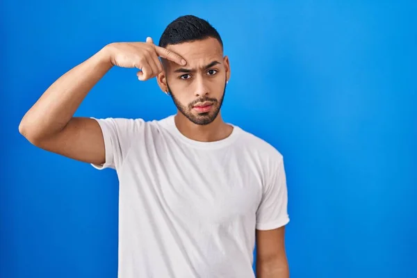 Young Hispanic Man Standing Blue Background Pointing Unhappy Pimple Forehead — Stock Photo, Image