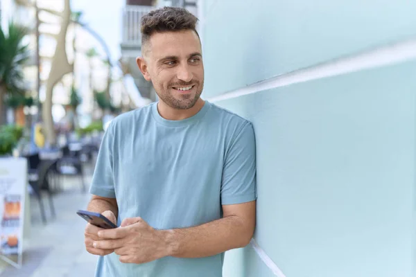 Joven Hombre Hispano Sonriendo Confiado Usando Smartphone Calle —  Fotos de Stock