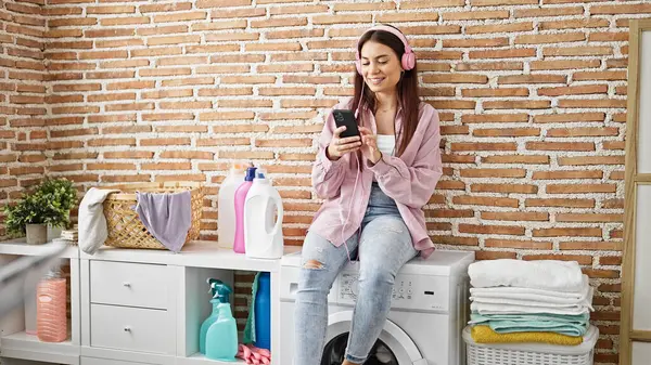 Young Beautiful Hispanic Woman Listening Music Waiting Washing Machine Laundry — Fotografia de Stock