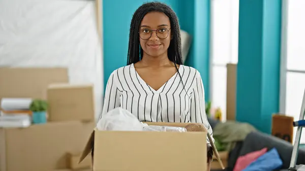 Afrikaans Amerikaanse Vrouw Glimlachen Zelfverzekerd Holding Pakket Nieuw Huis — Stockfoto