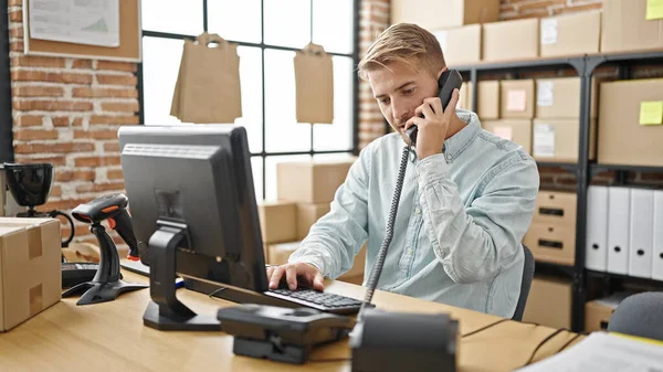 年轻的高加索人电子商务商人在办公室用计算机通过电话交谈 — 图库照片