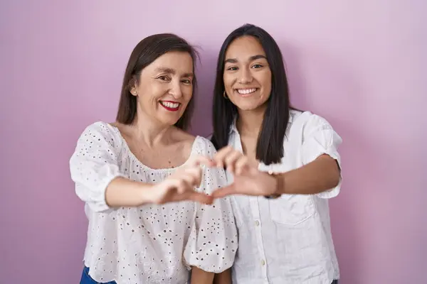 西班牙裔母亲和女儿一起笑着 用双手做着心形符号 浪漫的概念 — 图库照片