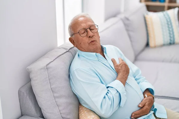 Yaşlı Kır Saçlı Kalp Krizi Geçiren Adam Evdeki Kanepede Oturuyor — Stok fotoğraf
