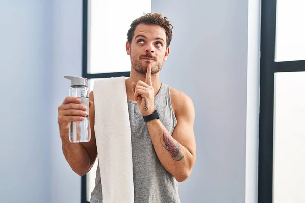Young Hispanic Man Wearing Sportswear Drinking Water Thinking Concentrated Doubt — Stock Photo, Image