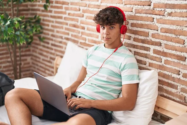 Mladý Hispánský Teenager Pomocí Notebooku Sluchátek Sedí Posteli Ložnici — Stock fotografie