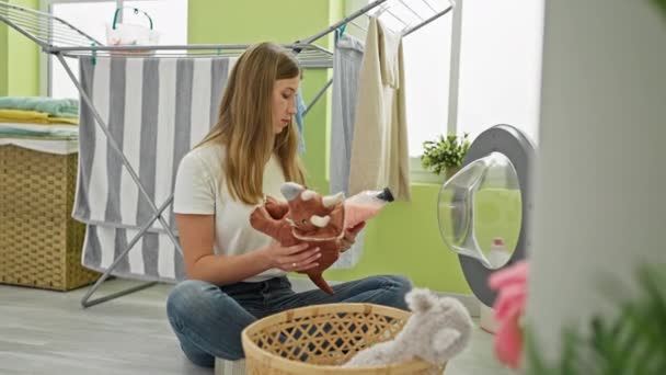 ワルカシアの母親と娘のシェアリングチェアの暖かいシーン 洗剤ボトルを持って 自宅で洗濯室でおもちゃを洗う — ストック動画