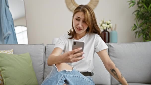 Jeune Femme Utilisant Smartphone Assis Sur Canapé Surpris Maison — Video