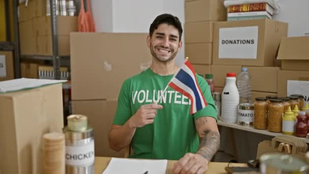 Jovem Hispânico Voluntário Sorrindo Confiante Segurando Bandeira Tailândia Centro Caridade — Vídeo de Stock