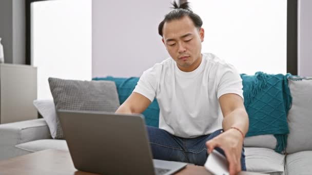 Jonge Chinese Man Met Behulp Van Laptop Praten Smartphone Zitten — Stockvideo