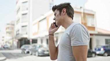 Genç İspanyol adam gülümsüyor. Kendine güveniyor. Akıllı telefondan konuşuyor.