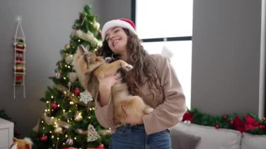 Köpekli genç İspanyol kadın Noel 'i evde dans ederek kutluyor.