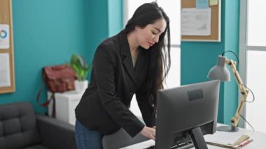 Genç ve güzel İspanyol iş kadını ofiste bilgisayar kullanarak kutlama yapıyor.