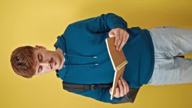 Sırt çantası takan genç İspanyol öğrenci, sarı arka plana şaşırdı.