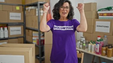 Orta yaşlı İspanyol kadın gönüllü yardım merkezinde gülümsüyor.