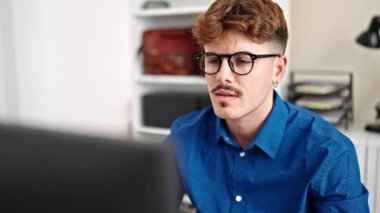 Ofiste gülümseyen bilgisayar ve akıllı telefon kullanan İspanyol bir iş adamı.