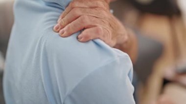 Middle age man suffering for backache sitting on sofa at home