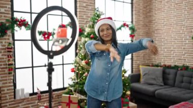 Afrikalı Amerikalı kadın Noel 'i kutluyor. Akıllı telefonuyla dans videosu kaydediyor.