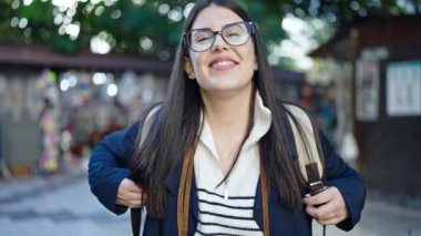 Sokak pazarında gülümseyen sırt çantası takan İspanyol bir turist.