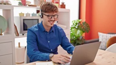 Genç İspanyol iş adamı yemek odasında video görüşmesi yapıyor.