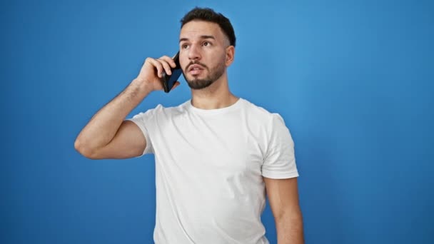 Ung Arabiska Man Talar Smartphone Ser Titta Över Isolerad Blå — Stockvideo
