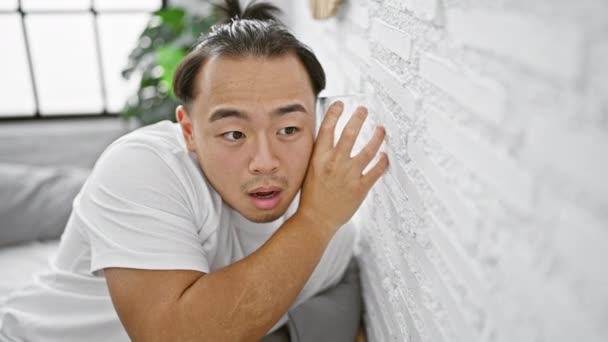 Meraklı Genç Çinli Adam Gizlice Yatak Odasının Duvarından Gizlice Dinliyor — Stok video