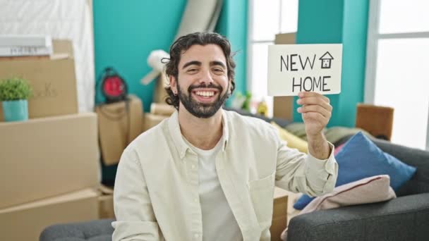 Jovem Hispânico Sorrindo Confiante Apontando Para Novo Papel Casa Nova — Vídeo de Stock