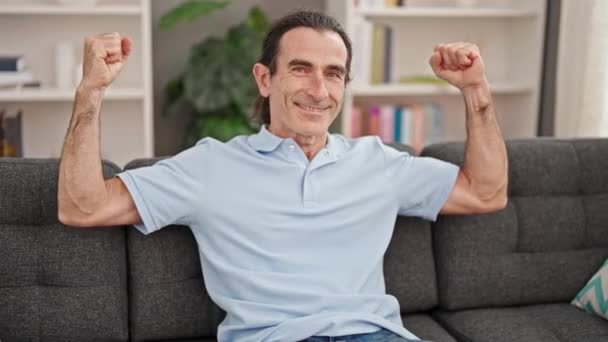 Homem Meia Idade Fazendo Gesto Forte Com Braços Sentados Sofá — Vídeo de Stock