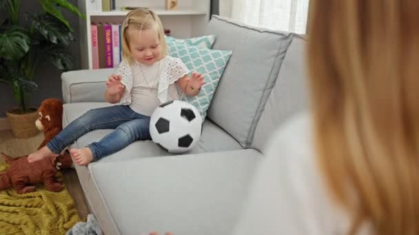 ハッピーな白人の母親と娘は一緒にボールをしたり 居間のソファーに快適に座ったり 家で過ごしたりします リラックスした家族の時間 — ストック動画