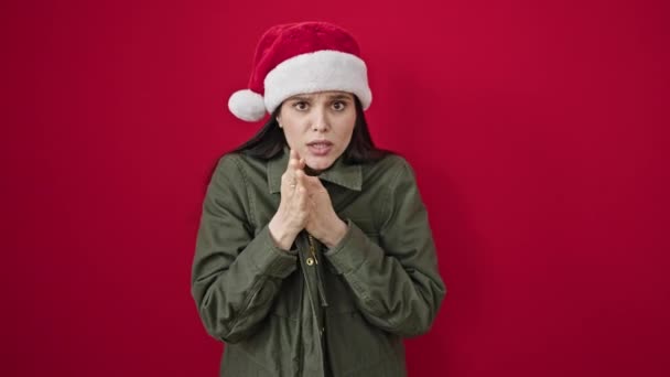 惊慌失措 头戴圣诞礼帽的女人 在孤独的红色背景下忍受着寒冷的折磨 — 图库视频影像