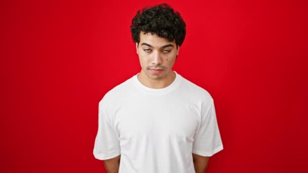 Mladý Latinsky Muž Usměvavý Sebevědomý Stojící Nad Izolované Červené Pozadí — Stock video
