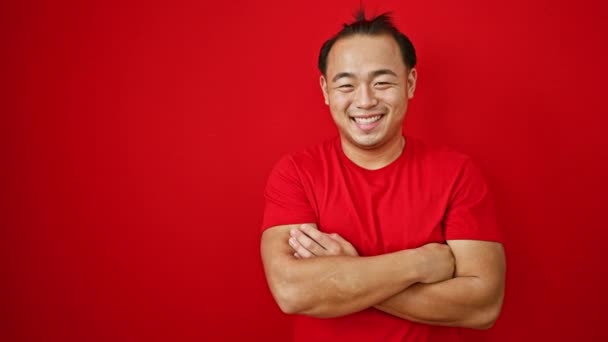 잘생긴 아시아 사람은 자신감을 제외하고 빨간색 배경에 기쁨과 긍정성을 — 비디오