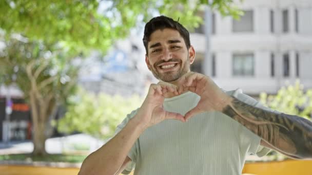 Νεαρός Ισπανός Χαμογελάει Αυτοπεποίθηση Κάνοντας Χειρονομία Καρδιάς Χέρια Στο Πάρκο — Αρχείο Βίντεο