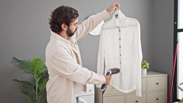 Çamaşır Odasında Gülümseyen Dikey Demir Makinesiyle Tişört Ütüleyen Spanyol Genç — Stok video