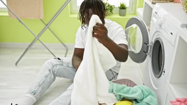 Çamaşır Odasında Gülümseyen Temiz Giysiler Kokan Afrikalı Amerikalı Bir Adam — Stok video