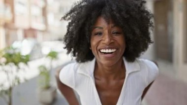 Sokakta kendine güvenen Afrikalı Amerikalı kadın gülümsüyor