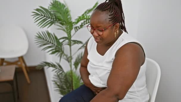 Σοβαρή Αφροαμερικανίδα Επιχειρηματίας Κάθεται Άνετα Μια Καρέκλα Αίθουσα Αναμονής Απορροφημένος — Αρχείο Βίντεο