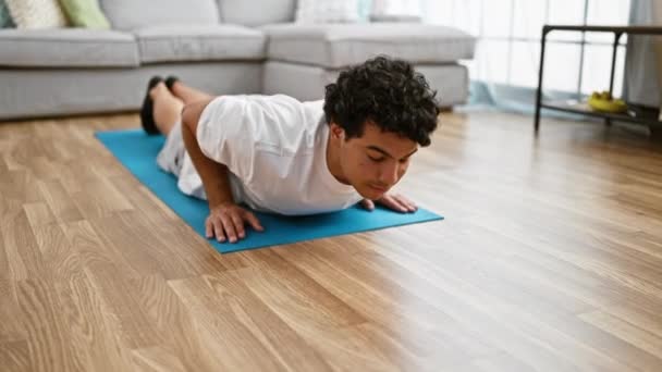 年轻的拉丁男子躺在地板上 练习瑜伽 伸展着身体回到家里 — 图库视频影像