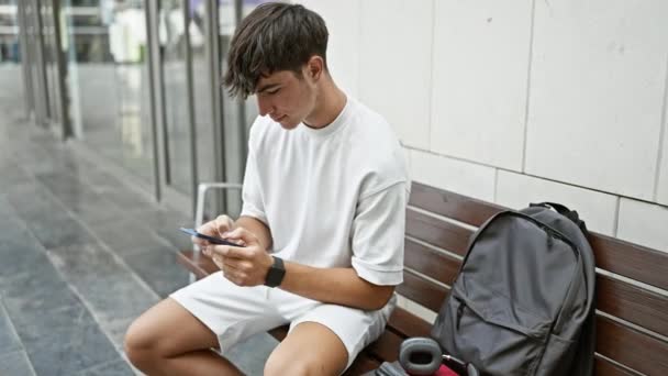 Adolescente Hispânico Confiante Radiante Digitando Smartphone Sentado Banco Universidade Ensolarado — Vídeo de Stock