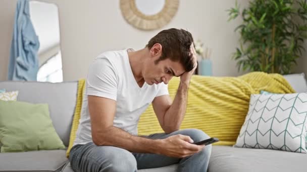 Hombre Hispano Joven Usando Teléfono Inteligente Sentado Sofá Estresado Casa — Vídeos de Stock