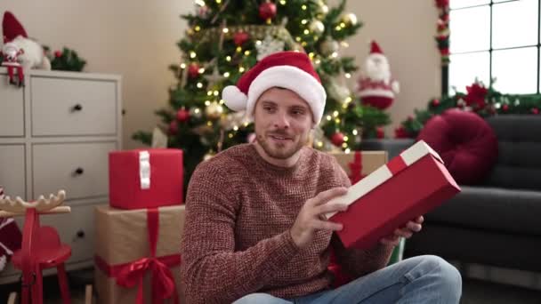 Junger Kaukasier Mit Geschenk Sitzt Hause Weihnachtsbaum — Stockvideo