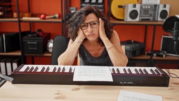 Músico Hispano Mediana Edad Apoyado Piano Con Expresión Triste Estudio — Vídeos de Stock
