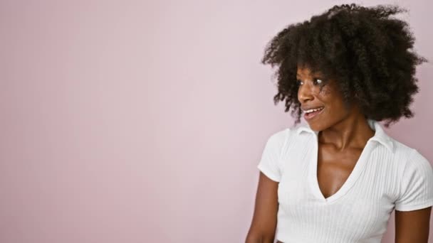 Femeia Afro Americană Zâmbind Arătând Spre Lateral Peste Fundal Roz — Videoclip de stoc