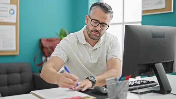 オフィスで文書を書くコンピュータを使用して灰色の髪の男のビジネスワーカー — ストック動画