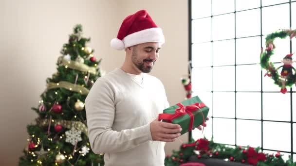 Mladý Hispánec Muž Objímání Dárek Stojící Vánočního Stromu Doma — Stock video