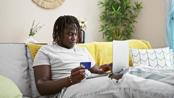 Африканский Американец Делает Покупки Ноутбуком Кредитной Картой Сидя Диване Дома — стоковое видео