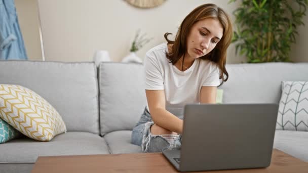 年轻女人躺在沙发上 躺在家里压力很大的笔记本电脑上 — 图库视频影像