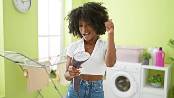 Αφρο Αμερικανίδα Που Κρατάει Κάθετο Σιδέρωμα Κάνοντας Χειρονομίες Στο Πλυσταριό — Αρχείο Βίντεο