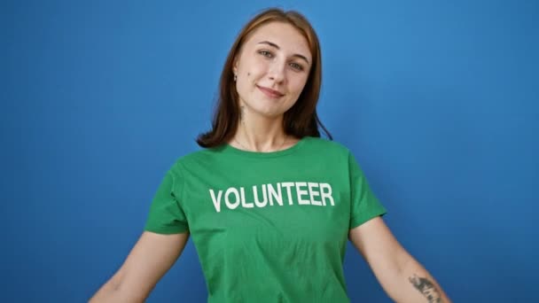 Jovem Mulher Apontando Para Voluntário Uniforme Sorrindo Sobre Fundo Azul — Vídeo de Stock