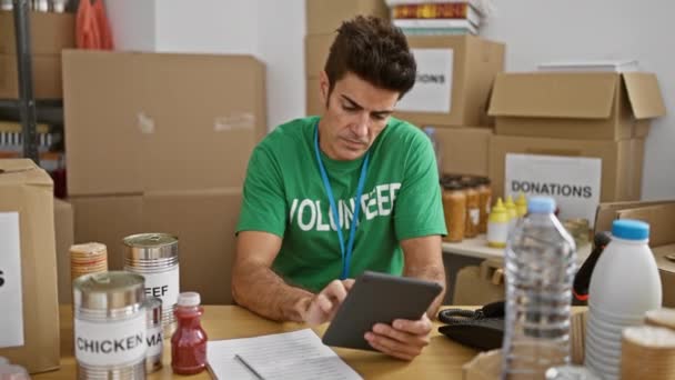 Joven Hispano Voluntario Usando Touchpad Comprobando Productos Centro Caridad — Vídeo de stock