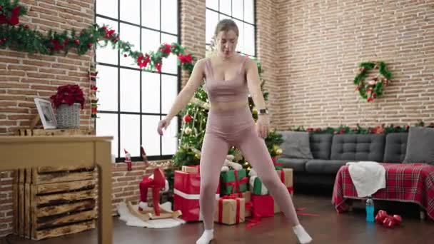 Νεαρή Ξανθιά Γυναίκα Γιορτάζει Χριστούγεννα Προπόνηση Πόδια Άσκηση Στο Σπίτι — Αρχείο Βίντεο